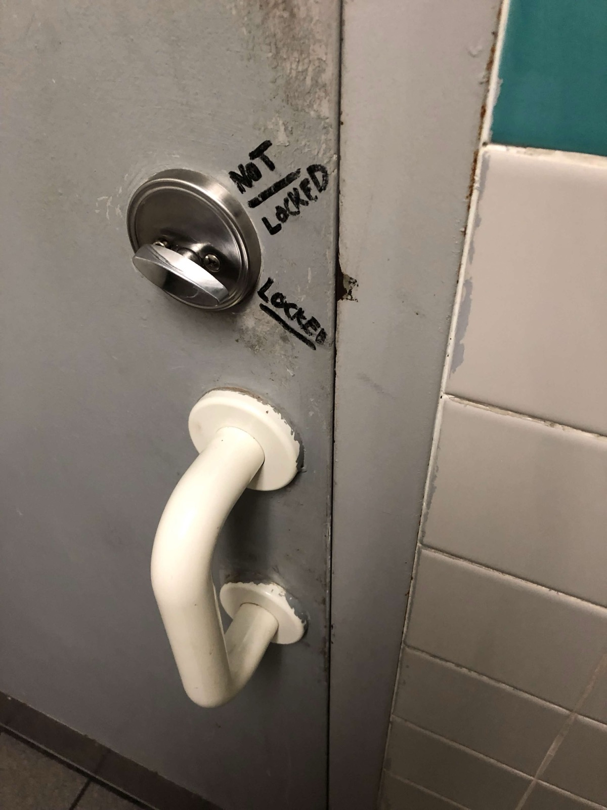Bathroom door with handwritten NOT LOCKED and LOCKED labels